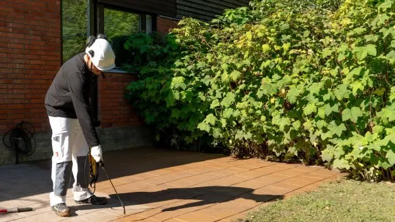 painter applying Patio Kivikuullote with a spray gun