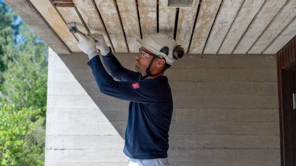 A painter preparing a wooden surface