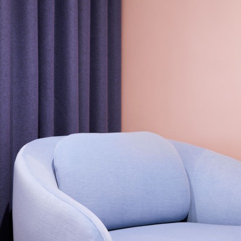 soft peach colour background wall with pastel blue sofa on front