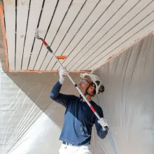Painter painting an exterior wooden area