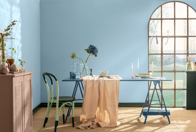 blue colour wall and green colour detailed dinner table with chairs