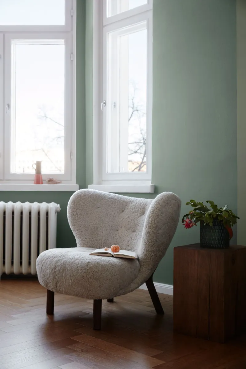 light green living room wall and soft round edge sofa chair