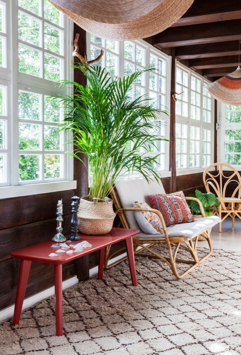 sun room with natural wooden furniture and green plants