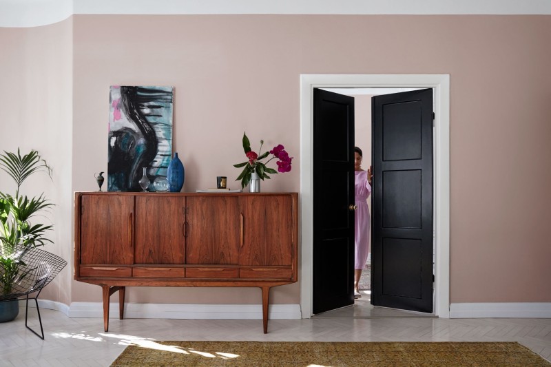 soft pink wall and black double door in living room
