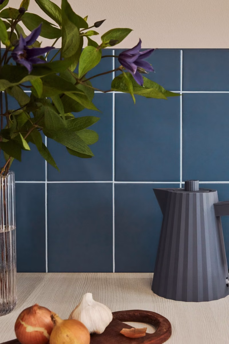 kitchen backsplash tiles painted in blue colour and white joint line