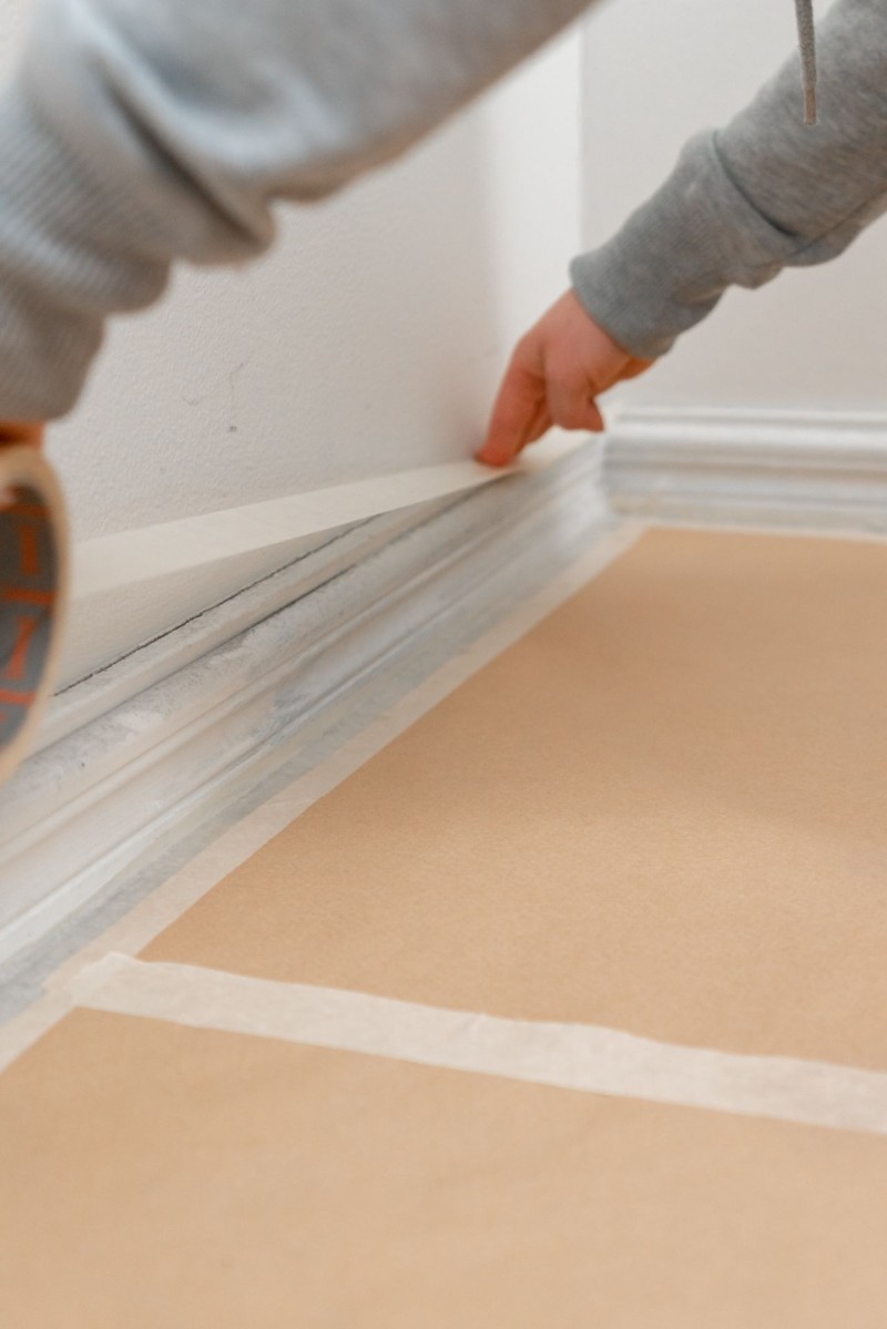 using masking tape to cover floor and skirting board