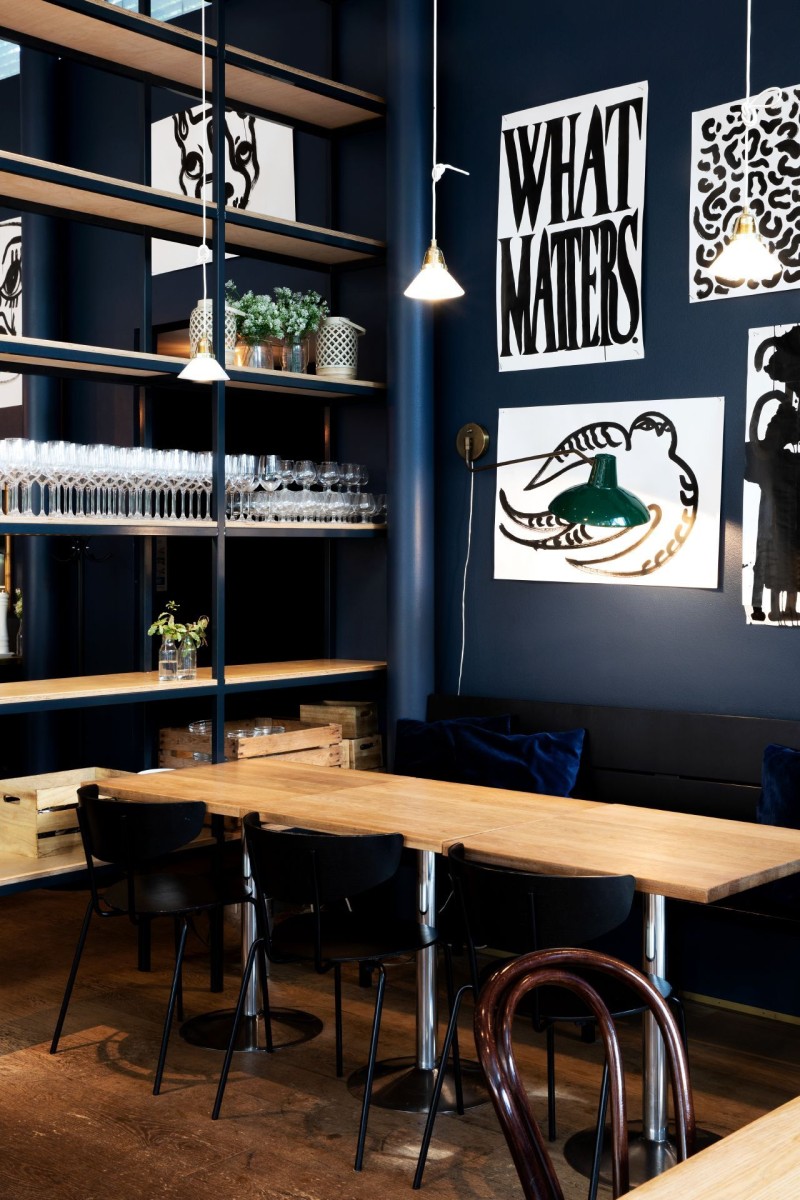 dark blue wall decorated with black and white graphic posters in restaurant