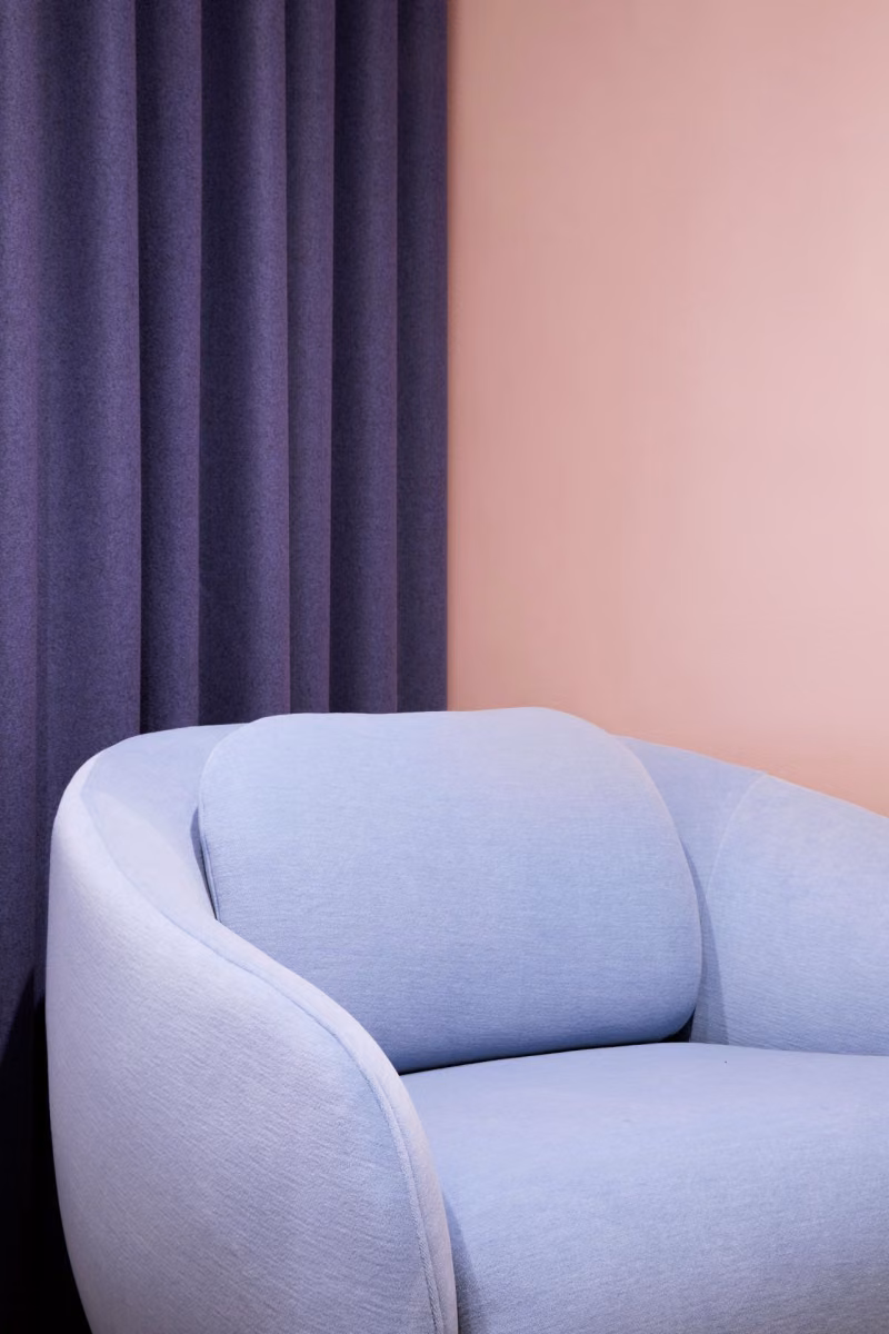 soft peach colour background wall with pastel blue sofa on front